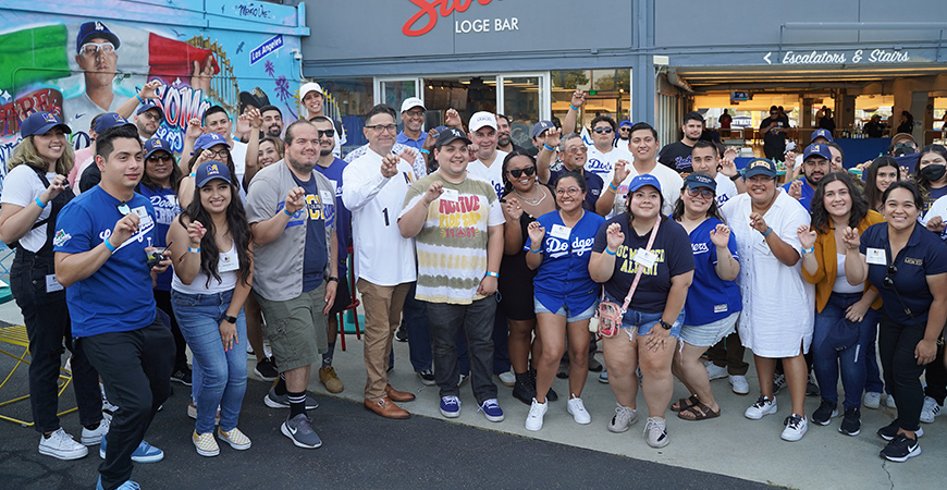 UC Merced Chancellor Juan Sánchez Muñoz and alumni pose for a photo at Dodger Stadium.